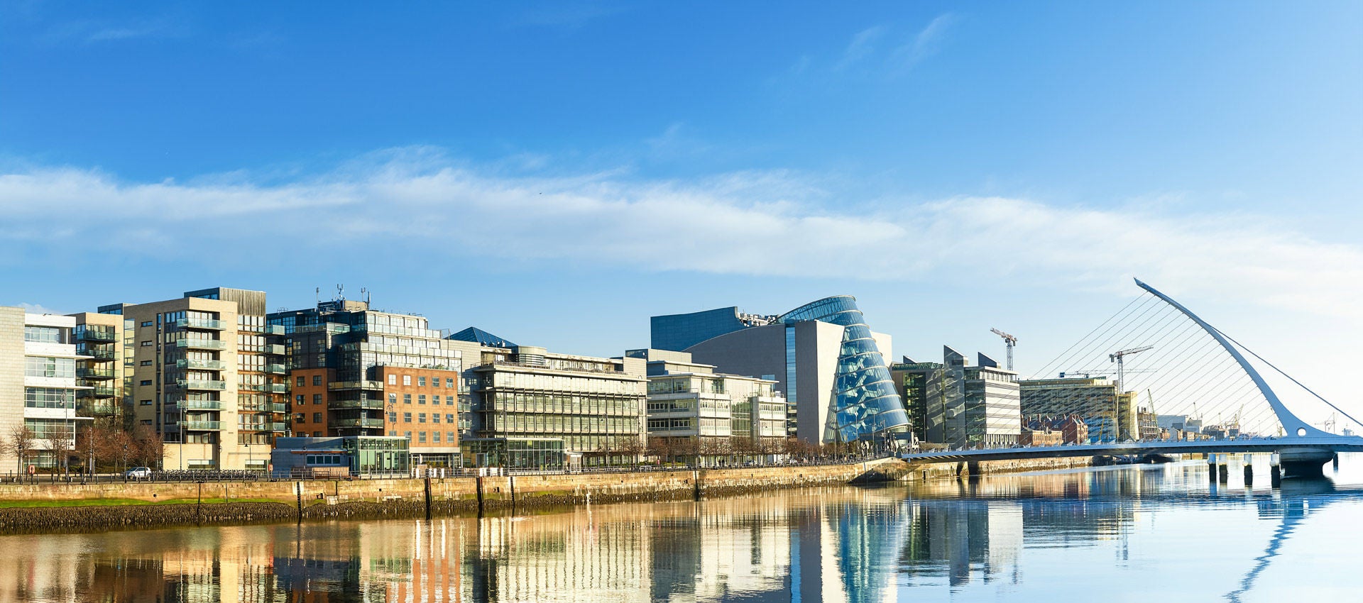 A sunny blue sky surrounds the north bank of the River Liffey in Dublin.