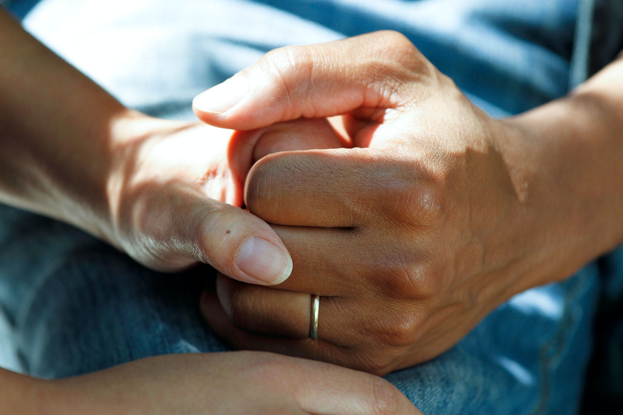 Two people holding hands at a concerning time. 