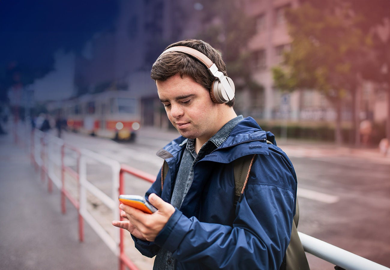 A man listens to music while waiting for the train.