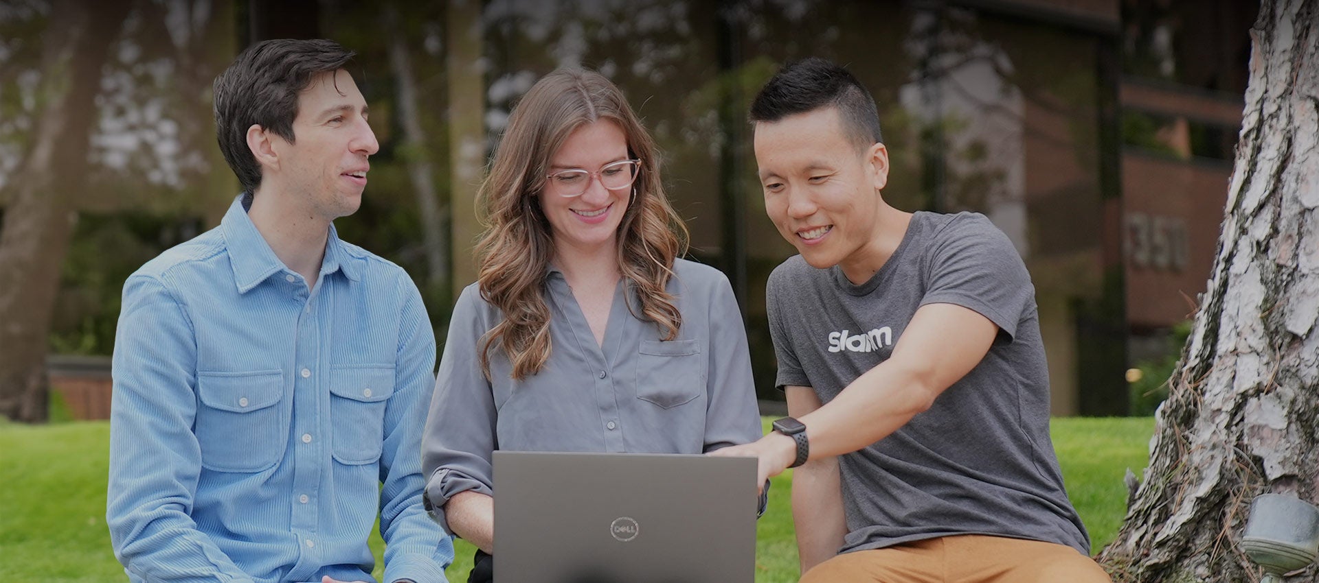 Six people collaborating around a table outdoors.