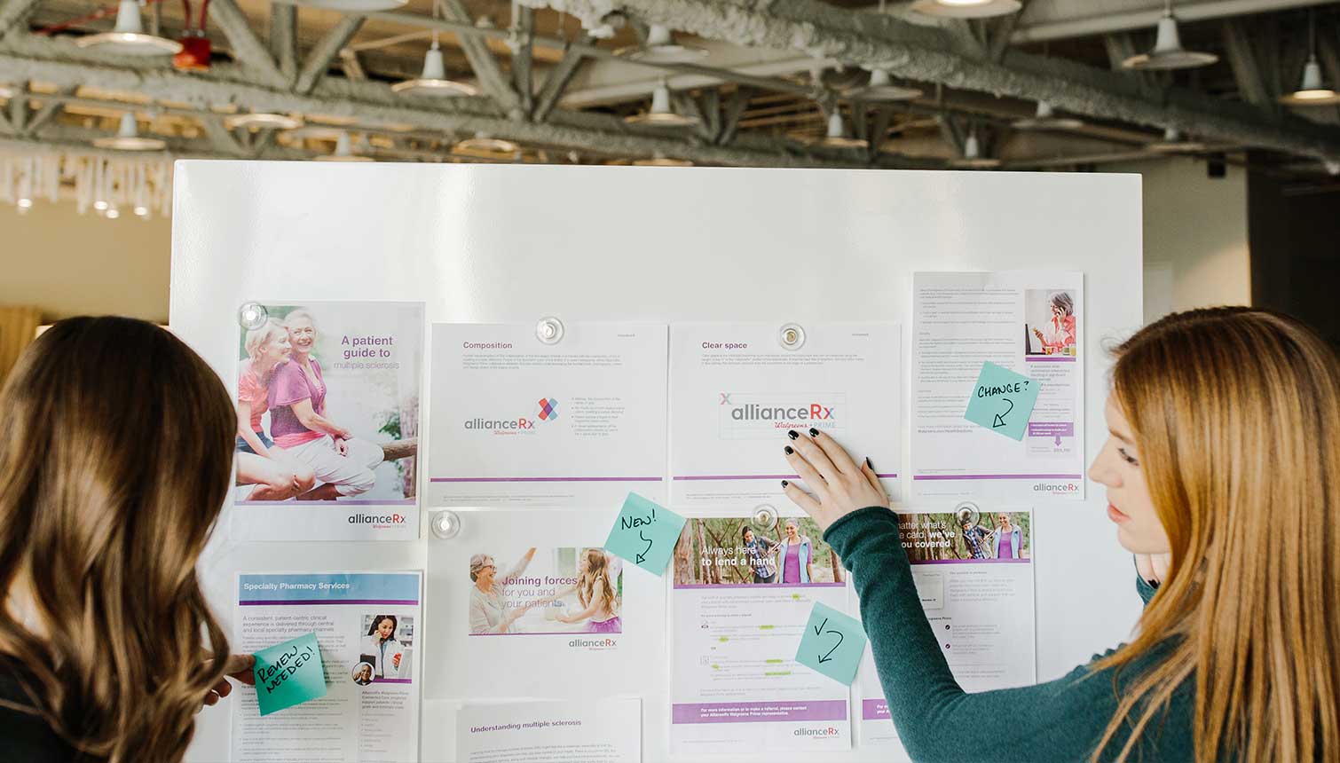 Two women planning on white board.