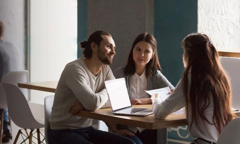 two women and a man sitting on a table