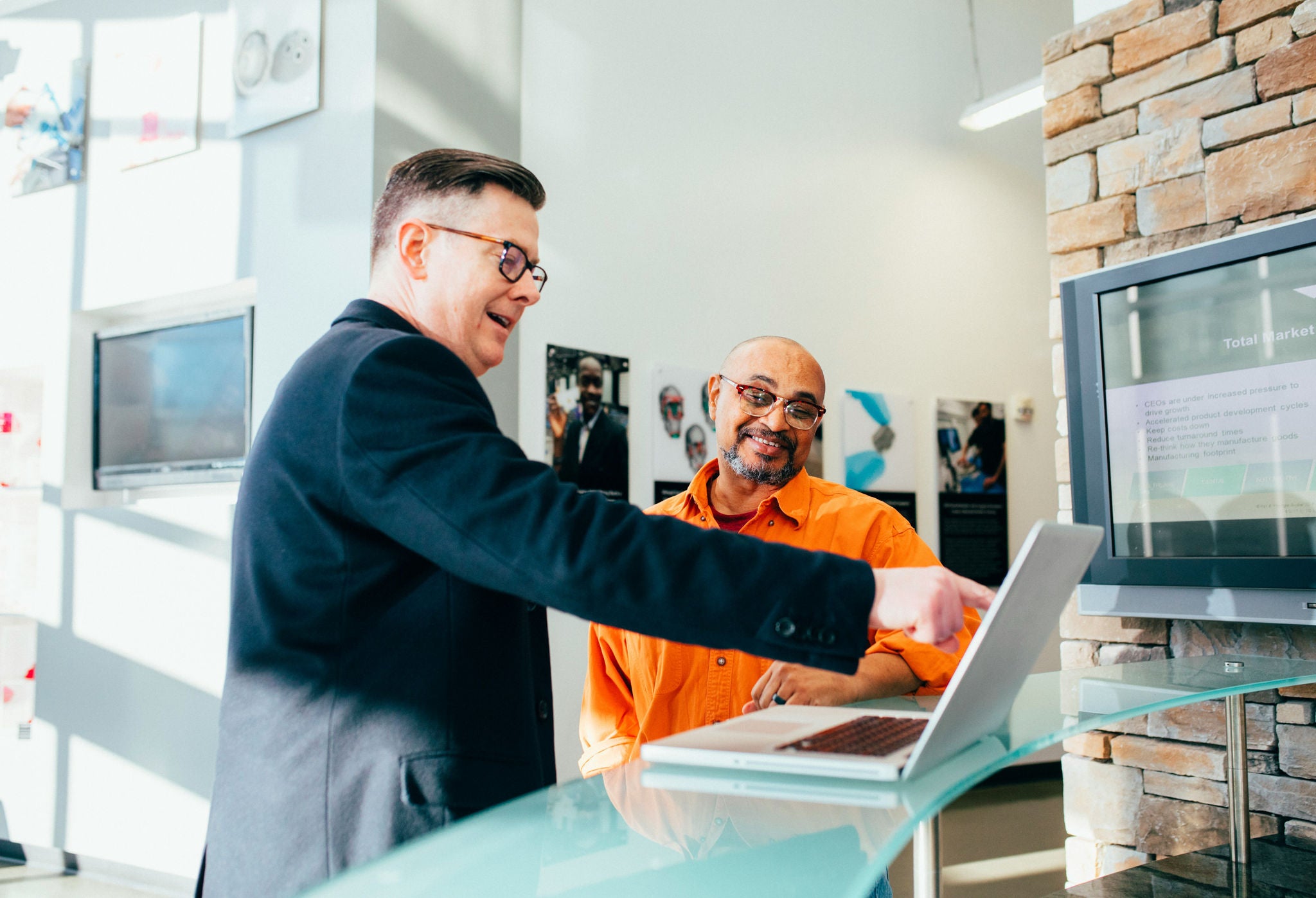 two coworkers talking in front of computer