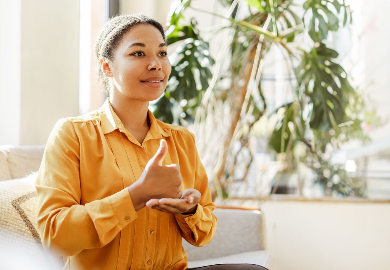 A woman uses sign language to communicate.