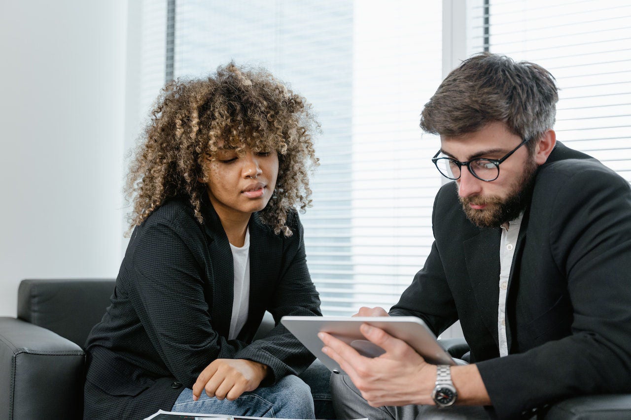 Two employees collaborating on a digital tablet.