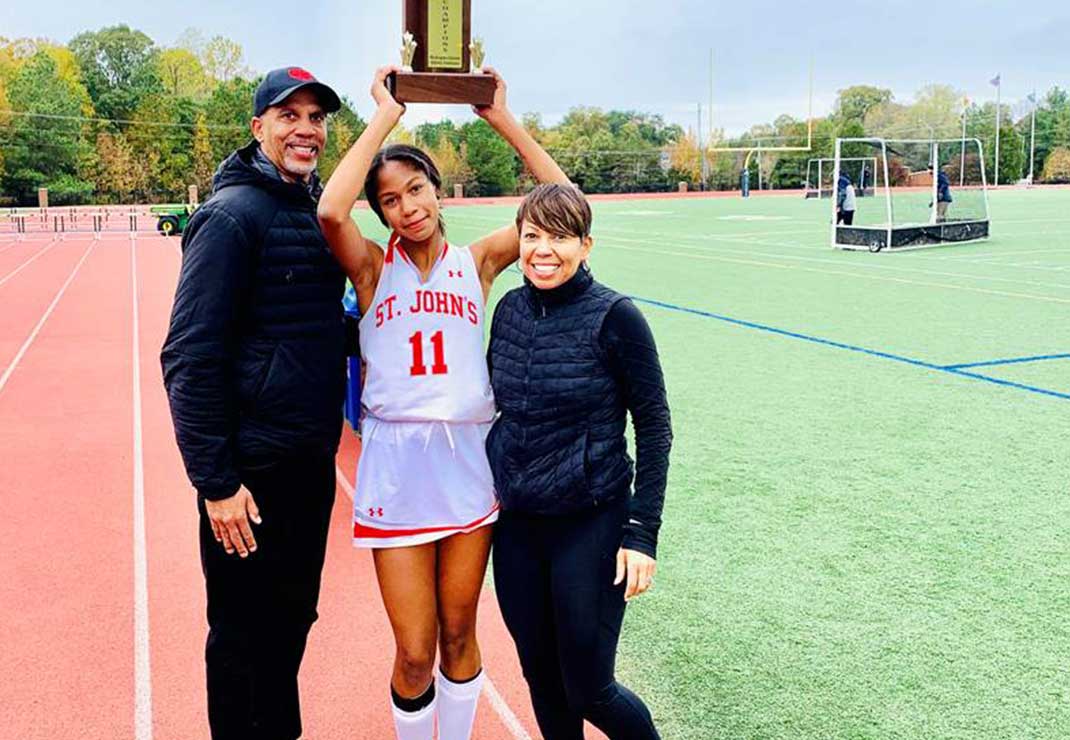 Yolanda Scott with family at track and field event holding a trophy