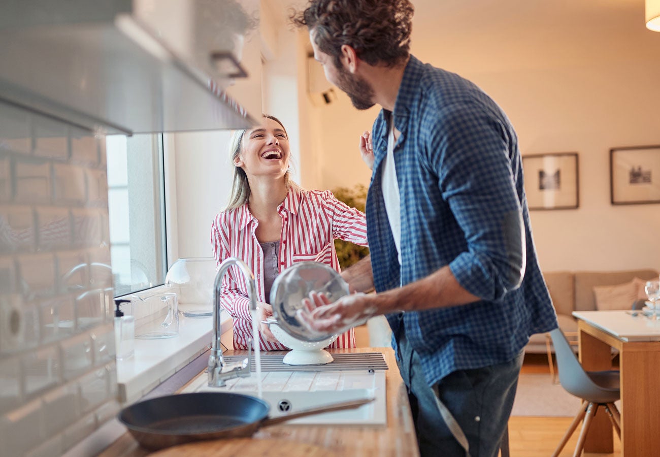 A couple does the dishes together.